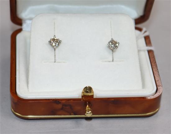 A pair of solitaire diamond ear studs